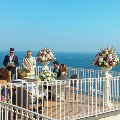 Trouwceremonie op een terras aan de Amalfikust met uitzicht over zee.