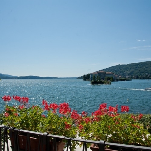 Uitzicht over het meer van Iseo in Noord Italië met bloemen en bergen op de achtergrond.