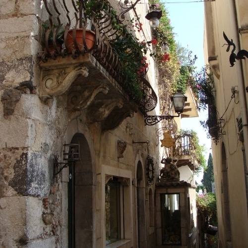 Smal straatje met balkon in een historisch dorp op Sicilië.