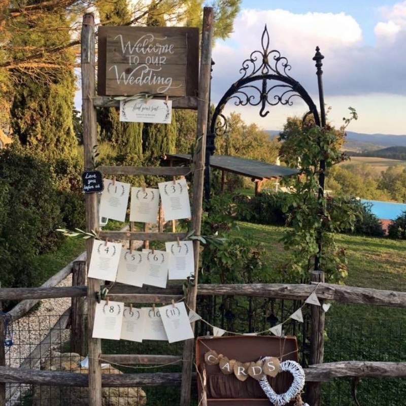 Welkomsttafel met programma en decoratie voor een bruiloft in Italië.