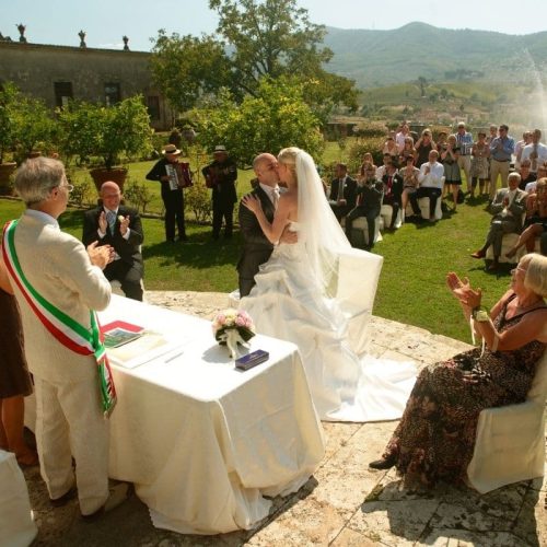 Wettelijke huwelijksceremonie op een buitenlocatie in Italië met gasten.